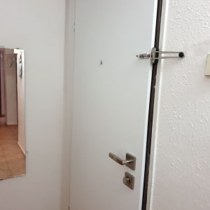 דלת לבנה עם ידית ומנעול מתכת