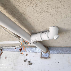 צינור פלסטיק לבן עם חיבורי זווית על קיר