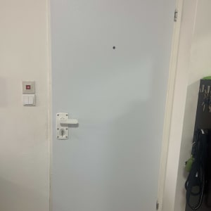 דלת לבנה עם ידית כסופה ומנעול