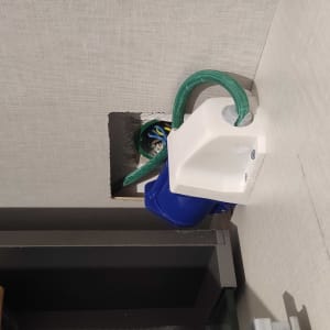 שקע חשמלי מותקן בקיר עם חוטים ירוקים וכחולים