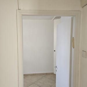 דלת פתוחה לחדר עם קירות צבועים בלבן