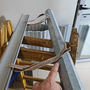 חלקי תריסים על סולם עץ ליד דלת זכוכית