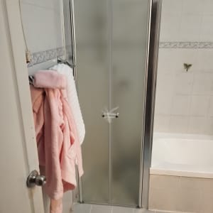 דלת מקלחון עם מגבות ורודות על הקיר