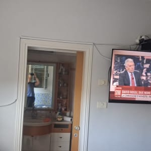 תליית טלוויזיה ומדף לממיר על הקיר בבית