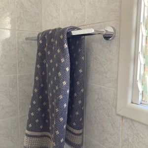 מגבת תלויה על מתלה מתכת בחדר אמבטיה