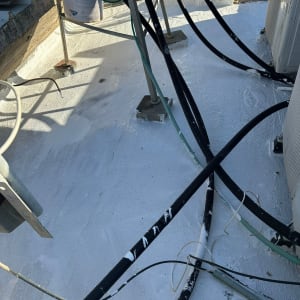 צינורות וכבל על גג אטום בחומר לבן