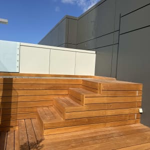 מדרגות עץ חיצוניות עם קיר רקע אפור ושמיים כחולים