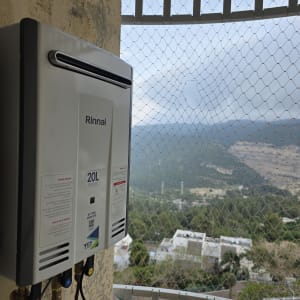 דוד חימום גז מותקן על קיר עם נוף הררי ברקע