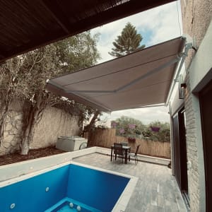 סוכך בד מתכת מותקן מעל מרפסת חיצונית