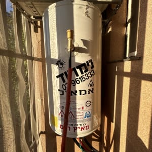 דוד שמש עם צינורות ומדבקות אזהרה