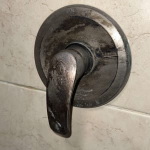 ידית ברז חלודה על קיר אריחים