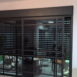 תריסים חשמליים מותקנים על חלון גדול בבית