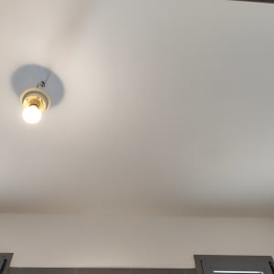 תקרה צבועה בלבן עם מנורה דולקת