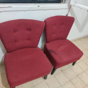 שני כיסאות אדומים עם כתם על אחד מהם