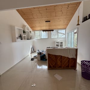 חדר עם תקרה מעץ, קירות צבועים ולוח עבודה