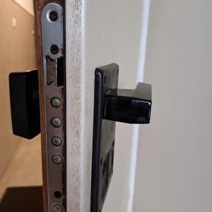 מנעול דלת עם ידית שחורה ומנגנון מתכת