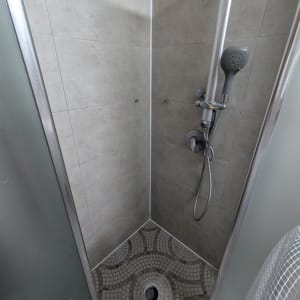 מקלחת עם ראש מקלחת ומרצפות מעוצבות