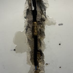 צינור חשוף בקיר עם חיבורי אינסטלציה