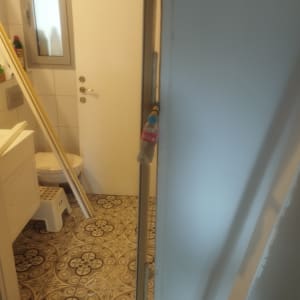 דלת לבנה בחדר אמבטיה עם רצפה מעוצבת