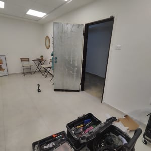 דלת מתכת פתוחה עם סימני ציפוי וכלי עבודה