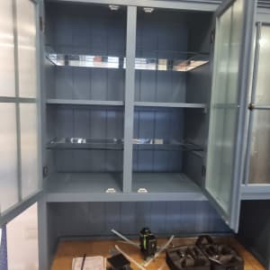 ארון עם דלתות זכוכית פתוחות ומדפים פנימיים