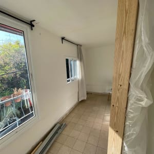 קירות גבס לבנים עם חלון גדול ופרופילים ממתכת