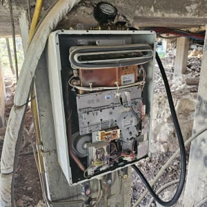 מחמם מים בגז פתוח במהלך עבודת תיקון והתקנה