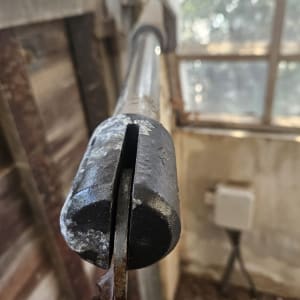 קצה מוט מתכת של שער חשמלי עם חלודה