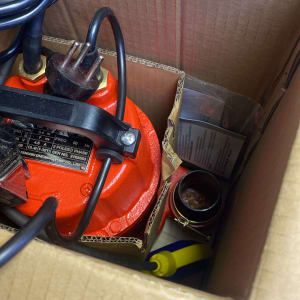 משאבה אדומה עם כבל חשמלי בתוך קופסה