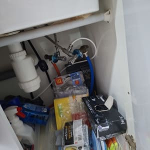 ארון מתחת לכיור עם צינורות וכלי ניקוי