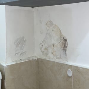 קיר עם סימני רטיבות ותיקוני צבע