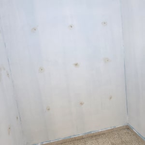 קיר צבוע עם תיקונים על הרצפה