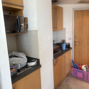 מטבח עם כלים ומוצרי ניקוי על השיש והרצפה