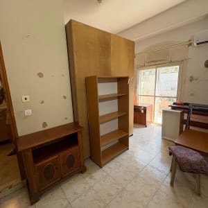 חדר עם רהיטים שונים, כולל מדפים ושולחנות