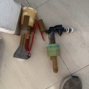 חלקי אינסטלציה על רצפה עם נעל בצד