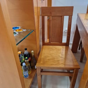 כיסא עץ ליד מדף עם בקבוקי שתייה