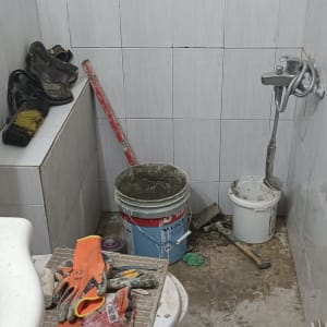 חדר אמבטיה עם כלי עבודה וחומרי בנייה