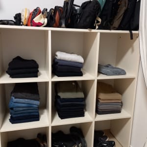 מדפים עם בגדים מקופלים, תיקים ונעליים מאורגנים