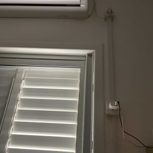 מזגן מותקן על קיר עם חוטי חשמל גלויים