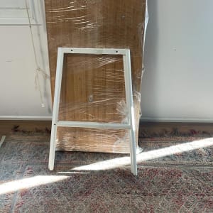 קרש עץ עטוף בניילון עם מסגרת מתכת לבנה