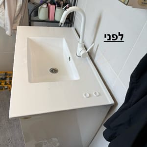 כיור לבן עם ברז בחדר אמבטיה