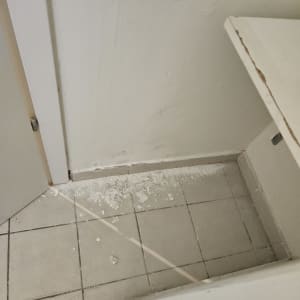 קיר עם סימני רטיבות וקרמיקה שבורה על הרצפה