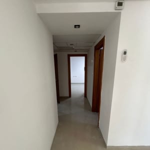 מסדרון עם קירות צבועים בלבן ודלתות עץ