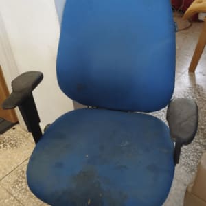 כיסא משרדי כחול עם כתמים על המושב והמשענת