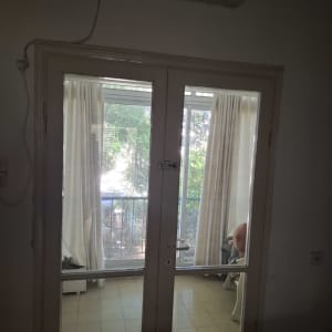 דלת זכוכית כפולה עם וילונות ברקע