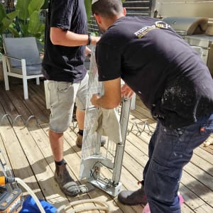 שני אנשים מתקנים מזגן על רצפת עץ