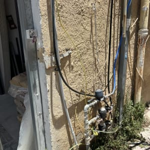 צינורות מים ומדי מים מחוברים לקיר חיצוני