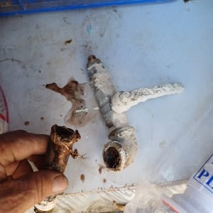 צינור חלוד וברז עם קורוזיה על שולחן עבודה