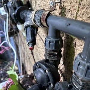 צינור פלסטיק עם מחברים וברזים על קיר