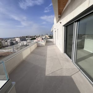 מרפסת נקייה עם רצפה בהירה ושמש חזקה